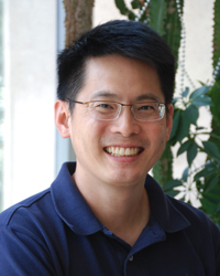 Dr. Liu standing in a plant-filled building lobby