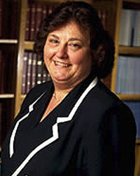 Dr. Bachevalier standing in a library before a bookcase